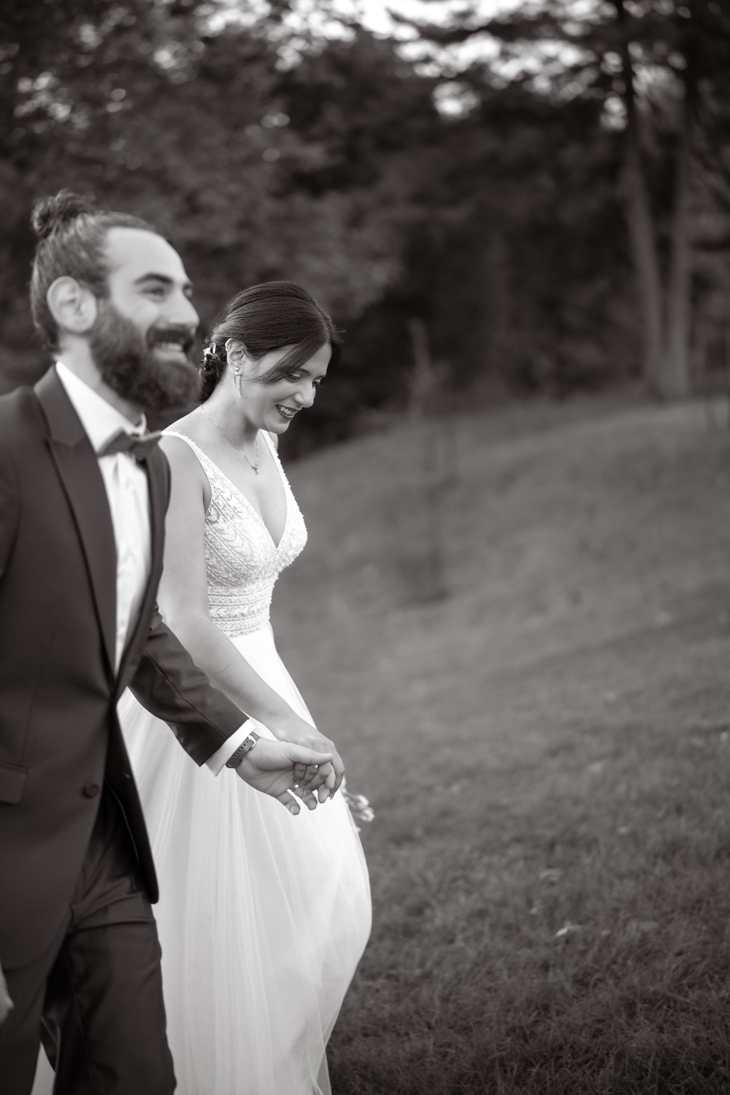 Black and white candid moment of couple sharing laughter outdoors.