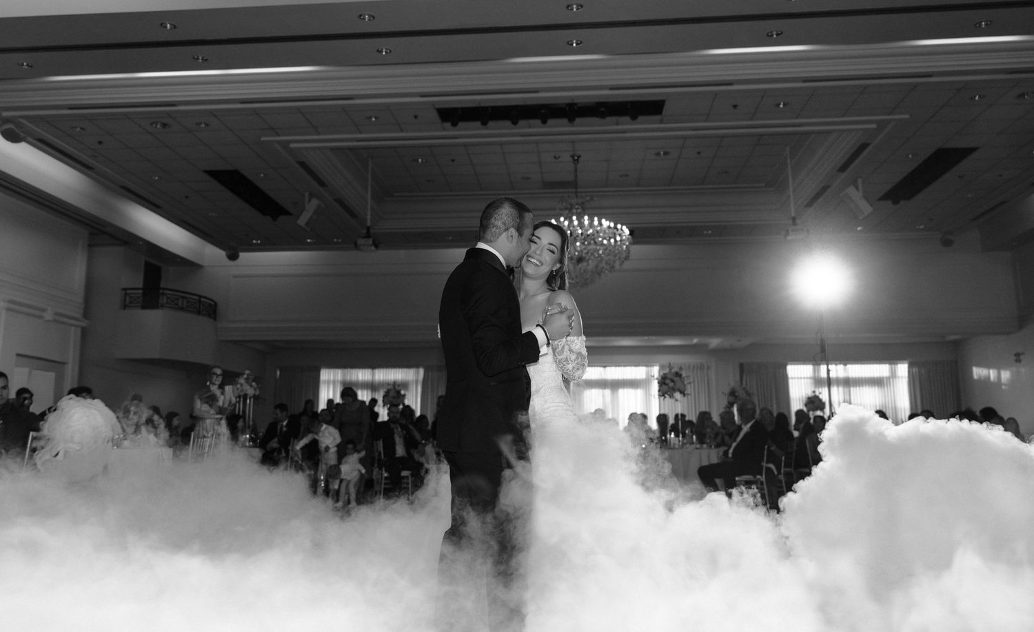 Thick white fog or smoke fills an indoor venue creating an atmospheric effect during an event.