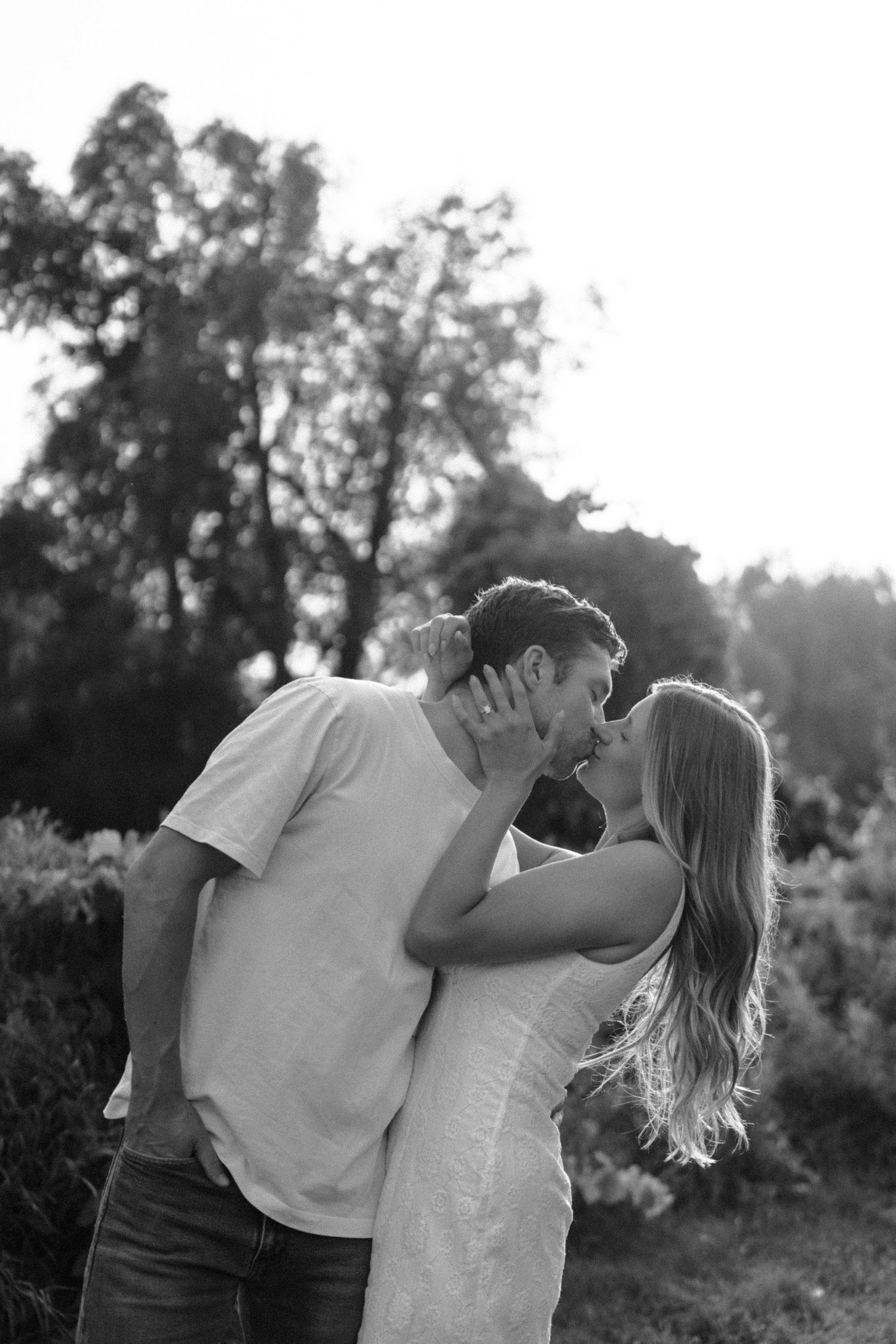Black and white photo series showing an intimate embrace between a couple in a natural outdoor setting.