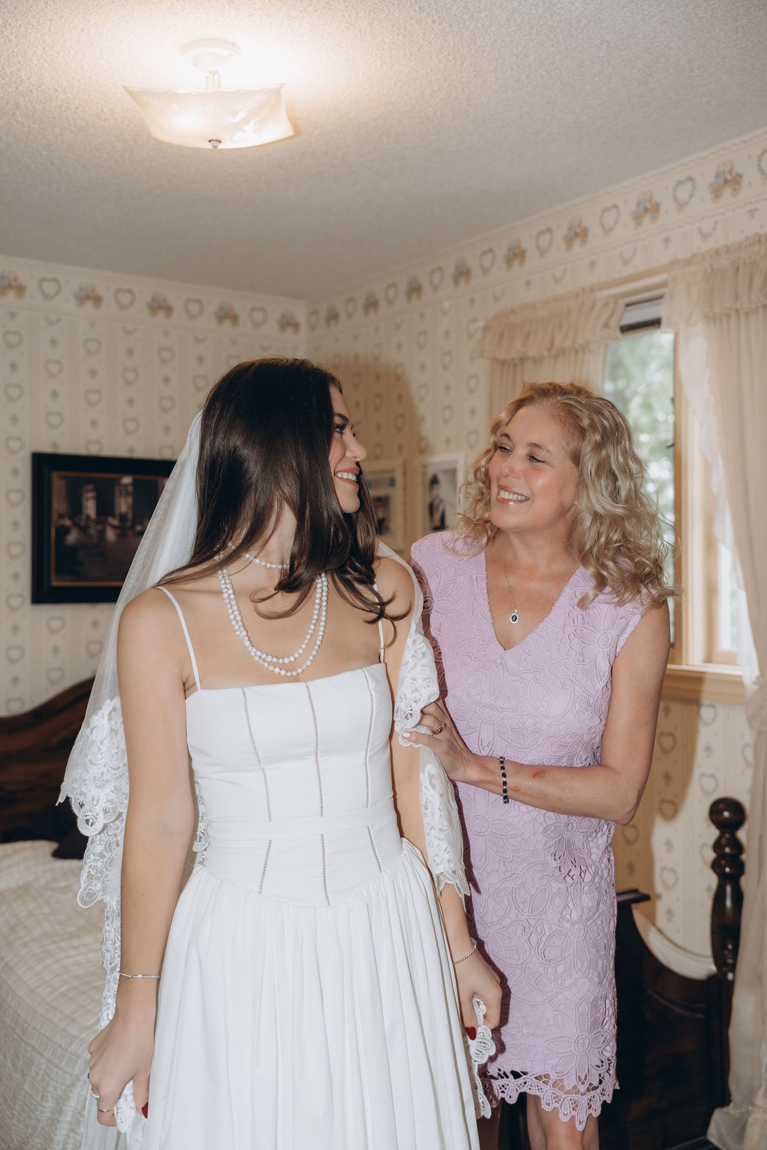 Wedding preparation moments showing emotional interactions between people in a delicate wallpapered room.