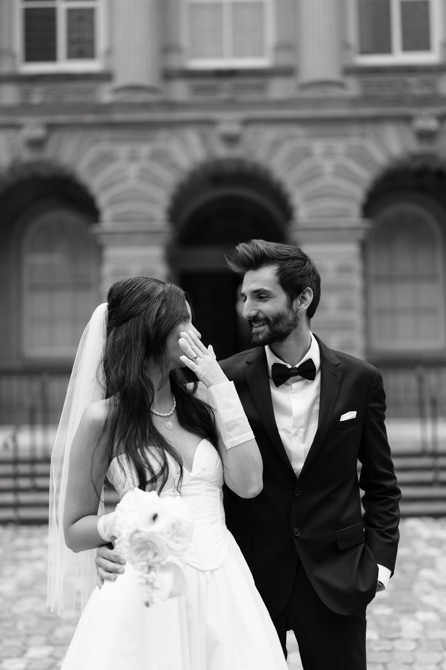 A bride and groom share a joyful candid moment together in black and white in Osgood Hall ​captured by AZ photo studio