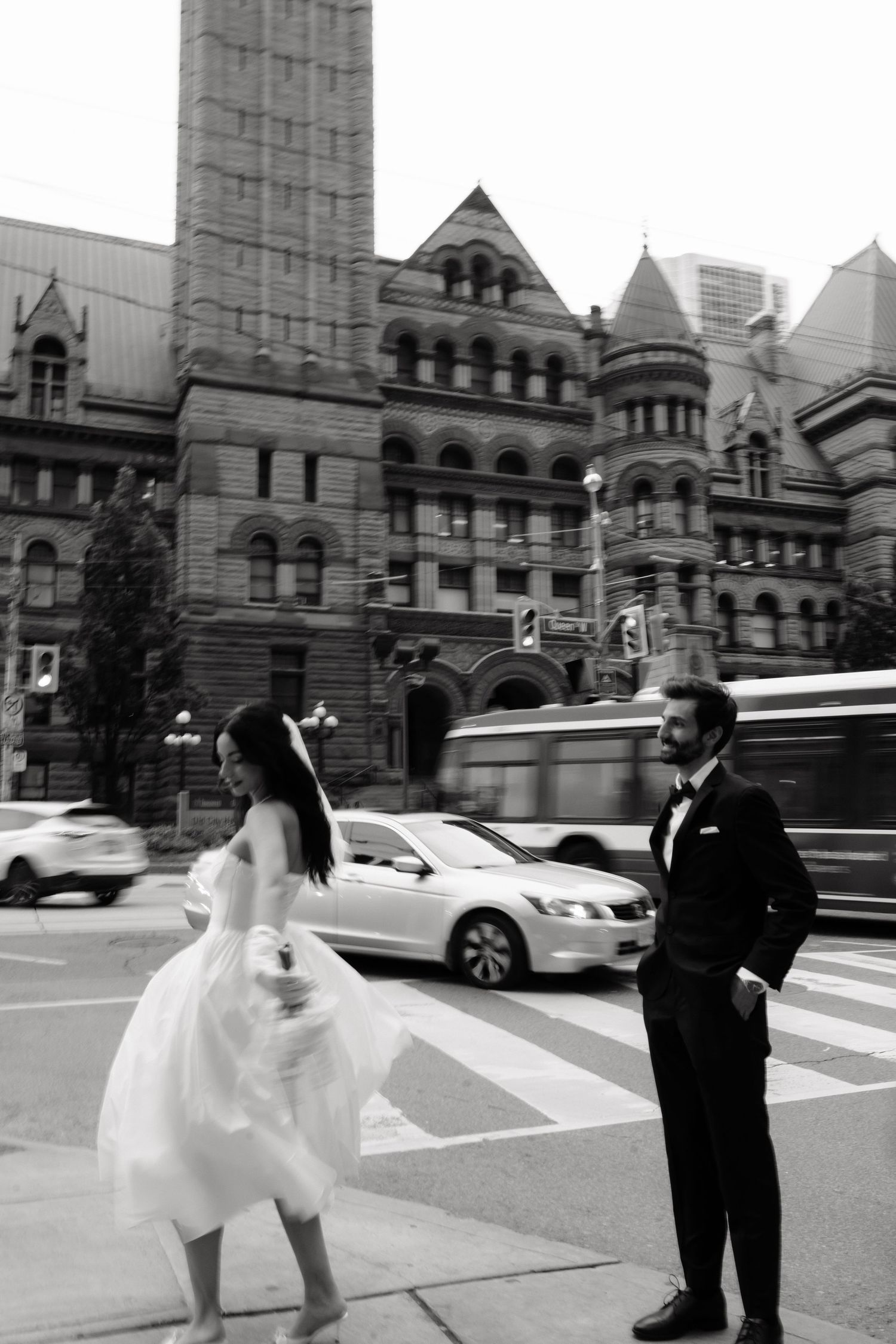 A couple poses in front of a historic stone building in a series of black and white wedding photos.