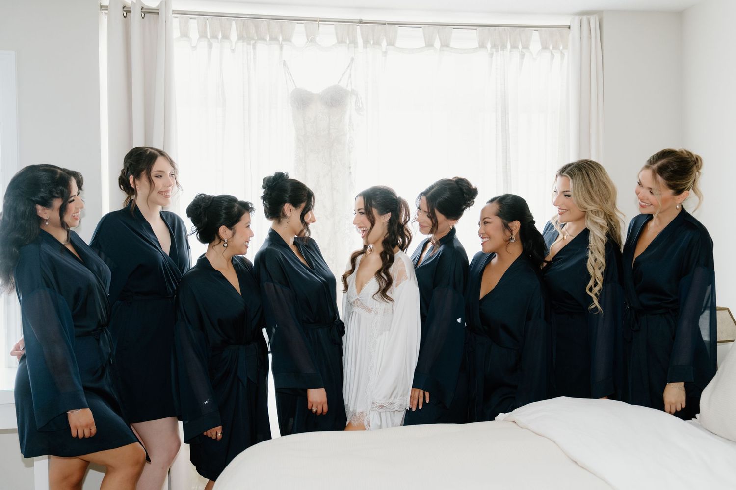 A panoramic view of business professionals in formal attire standing against a white wall in a bright room.