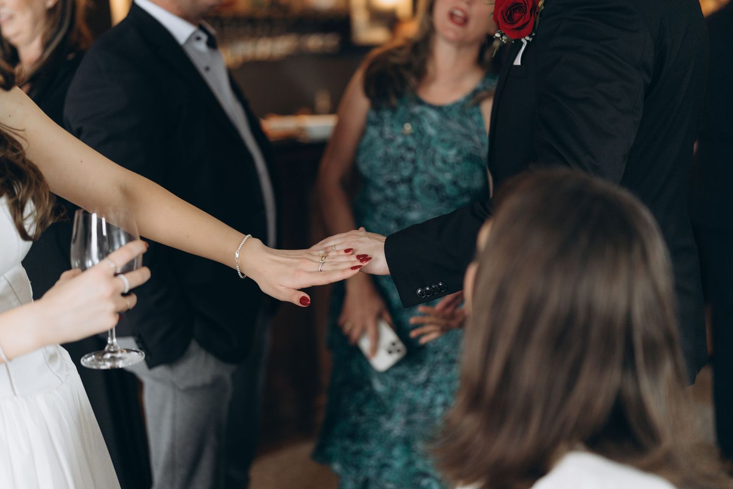 People dancing and celebrating at a wedding reception with strobe lights illuminating the dance floor.
