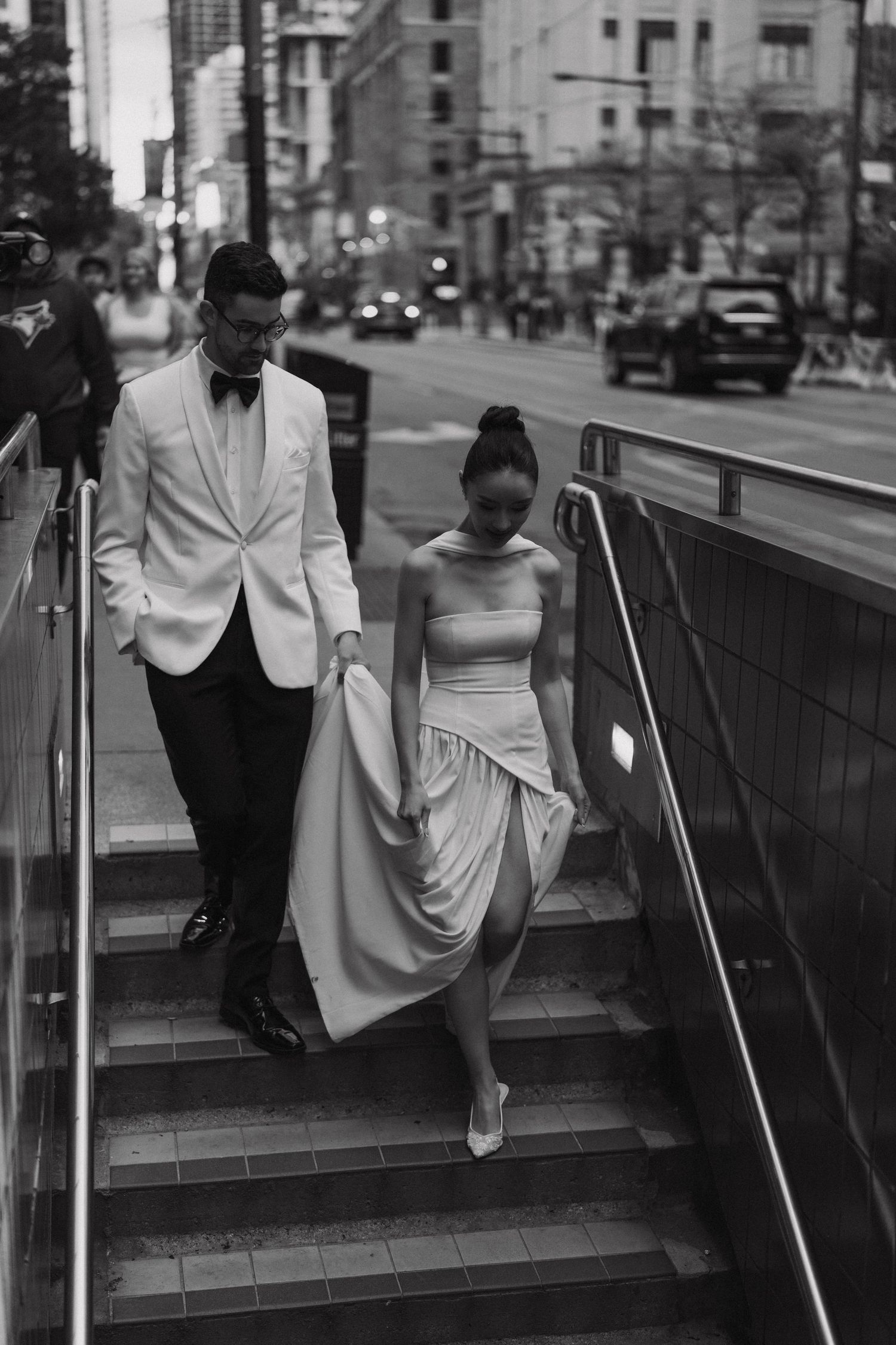 Vintage black and white fashion photograph series showing elegant couple descending subway station stairs.