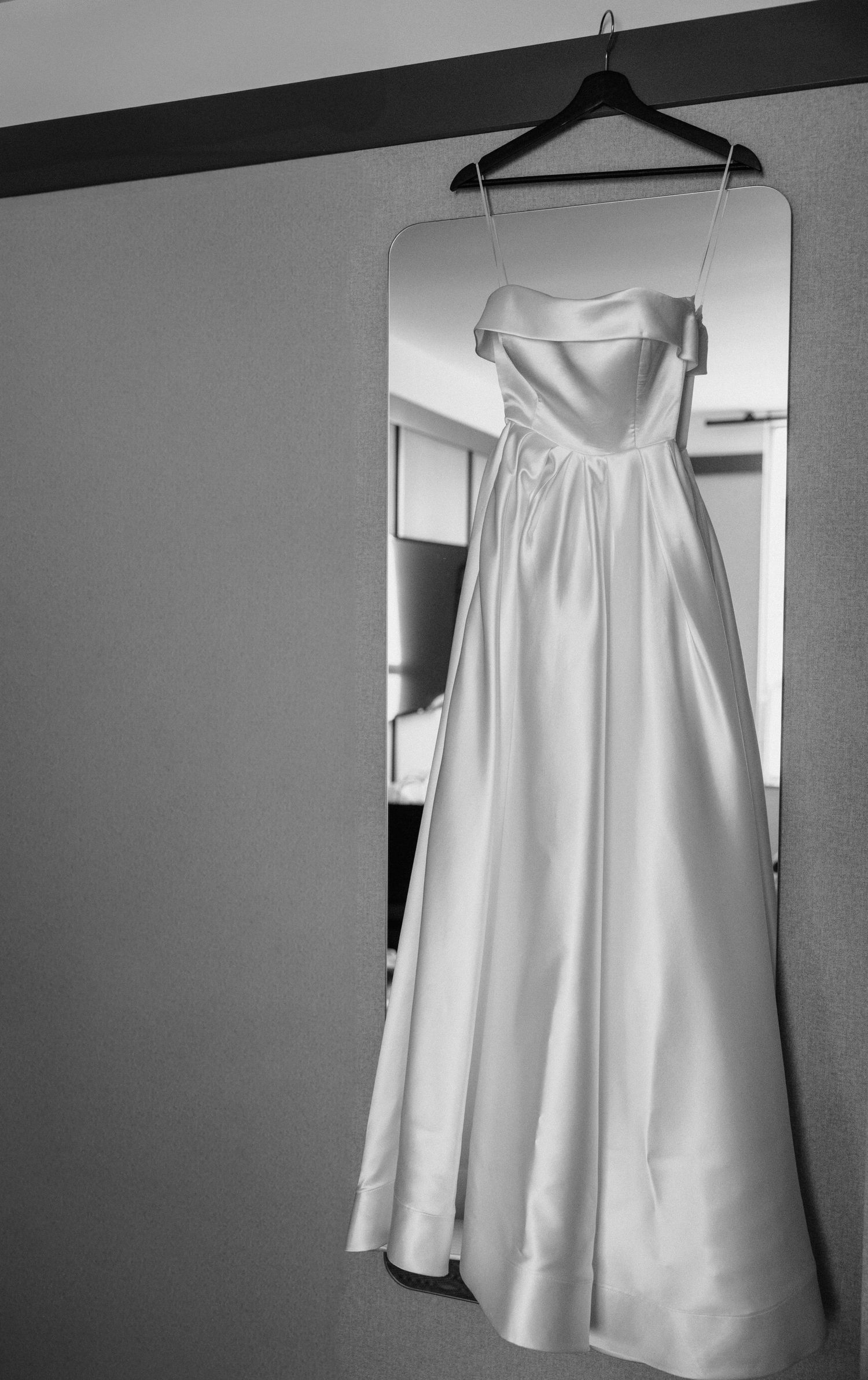 A white sleeveless dress hangs on a clothing hanger against a gray wall, shown from multiple angles.