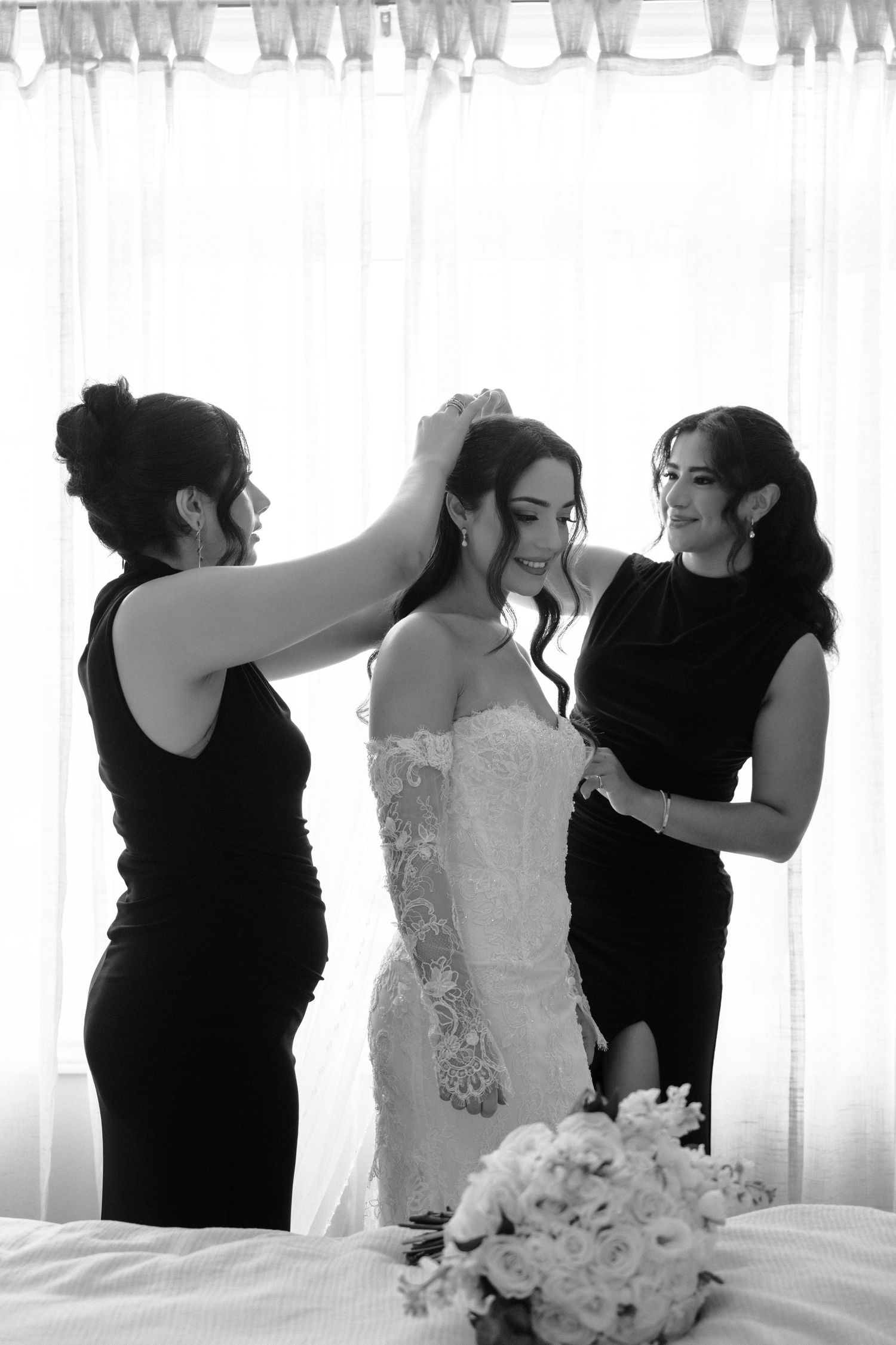 A series of black and white wedding photos showing emotional moments between guests and the bride in a white dress.