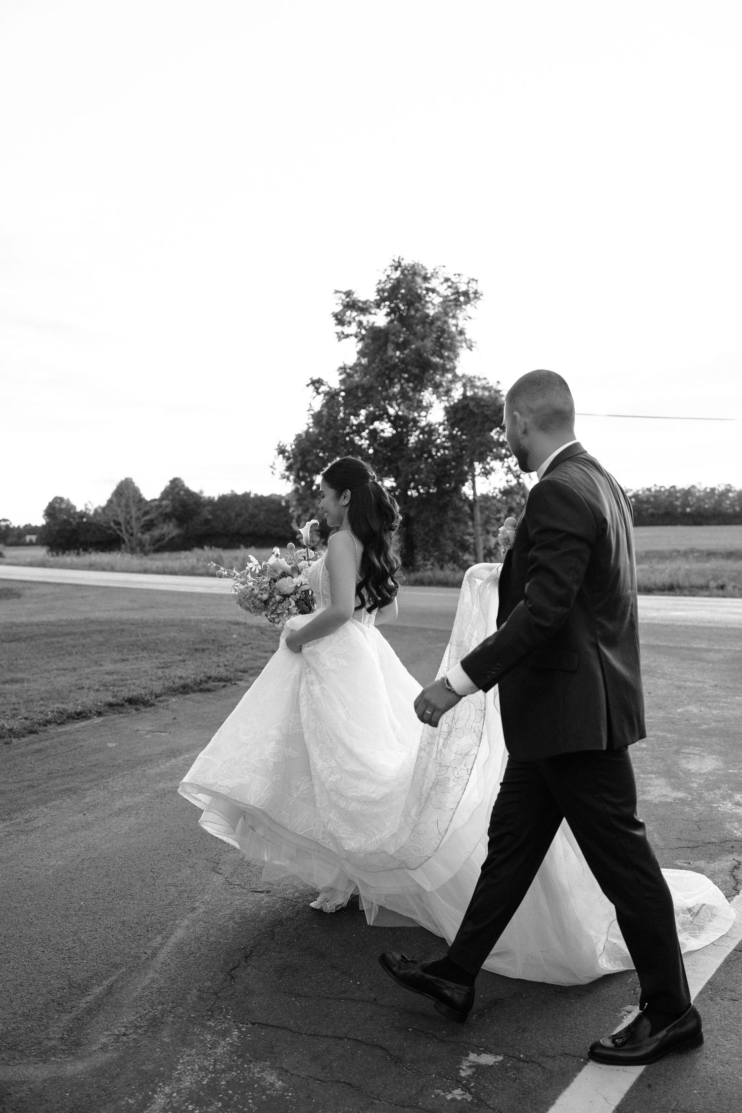 Black and white photo sequence shows a couple dancing playfully outdoors with the bride's dress flowing in the wind.