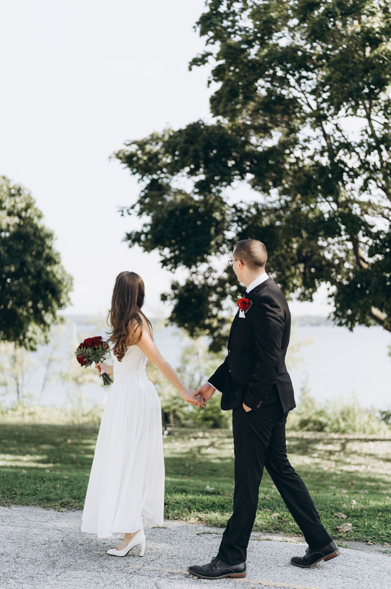 A flower girl and ring bearer walking down an outdoor path during a wedding ceremony at a scenic venue.