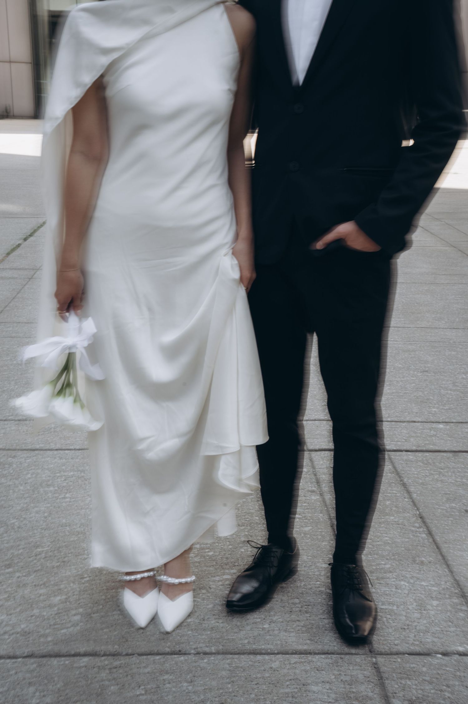 Four sequential photos showing details of formal wedding attire with black tuxedo shoes and white dress hem on stone pavement.