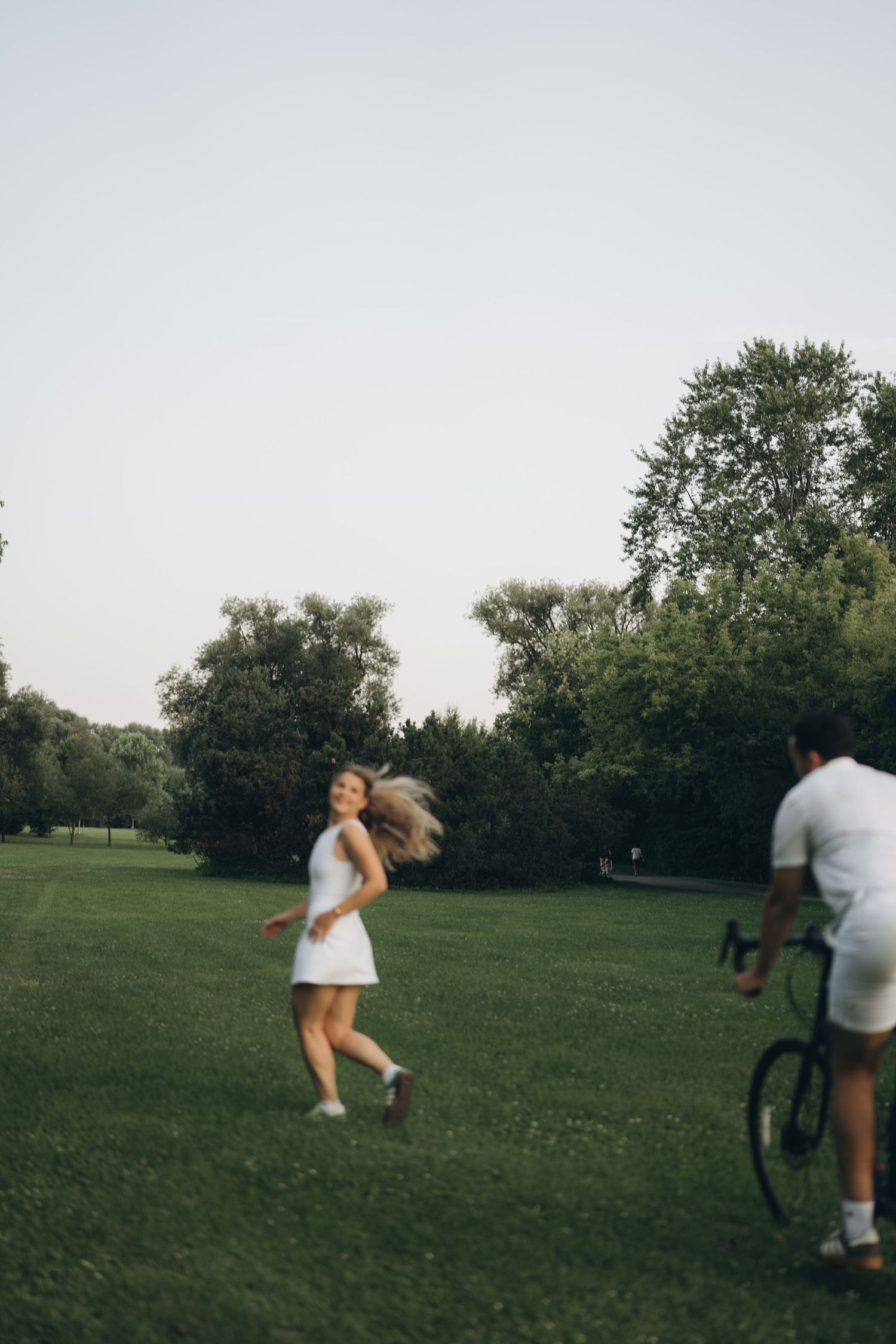 A sequence of photos showing people playing with a dog in a grassy field on a summer day.