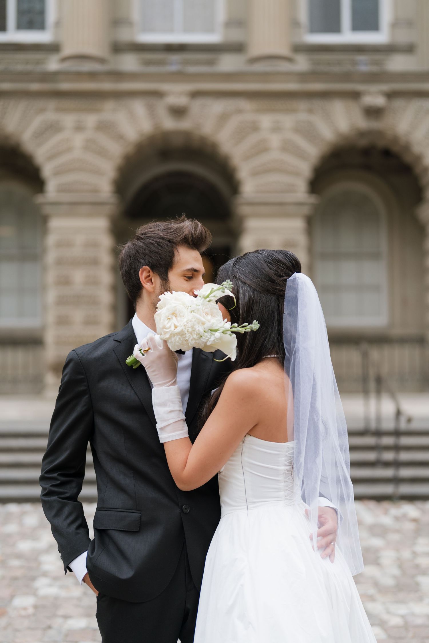 A romantic wedding photo sequence showing a couple sharing a tender kiss in front of Osgood hall captured by AZ photo studio