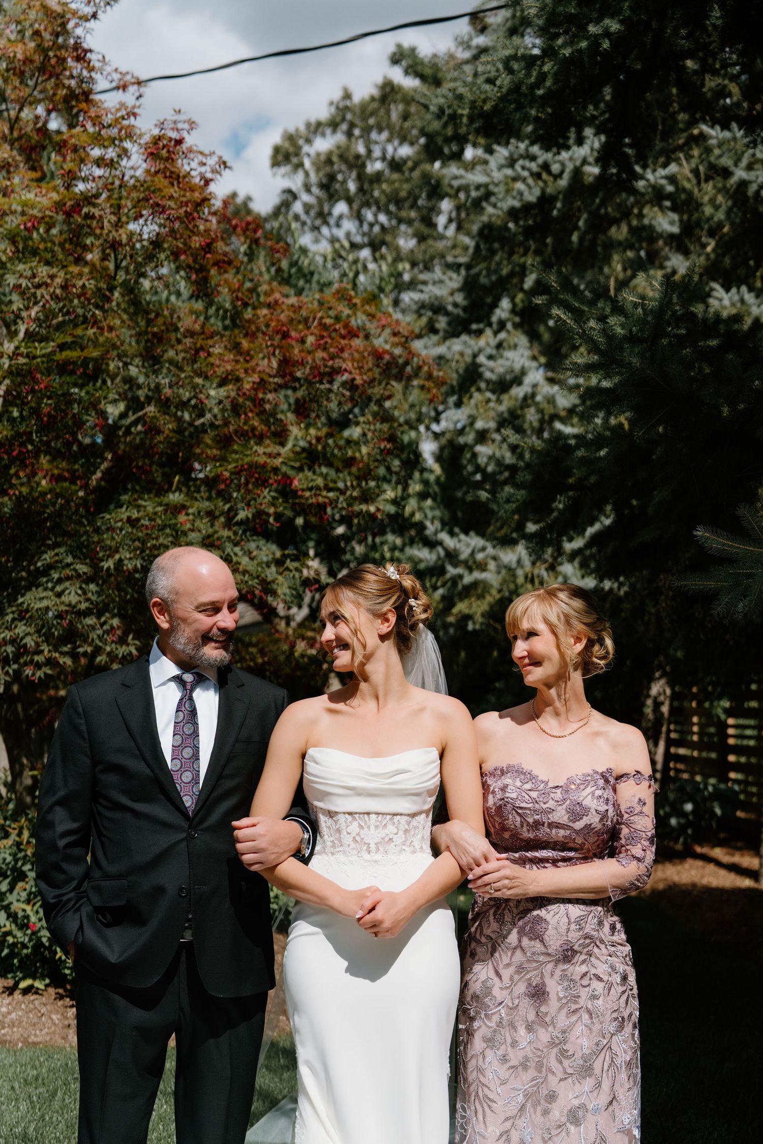 Wedding party members share joyful moments together during an autumn outdoor photo session.