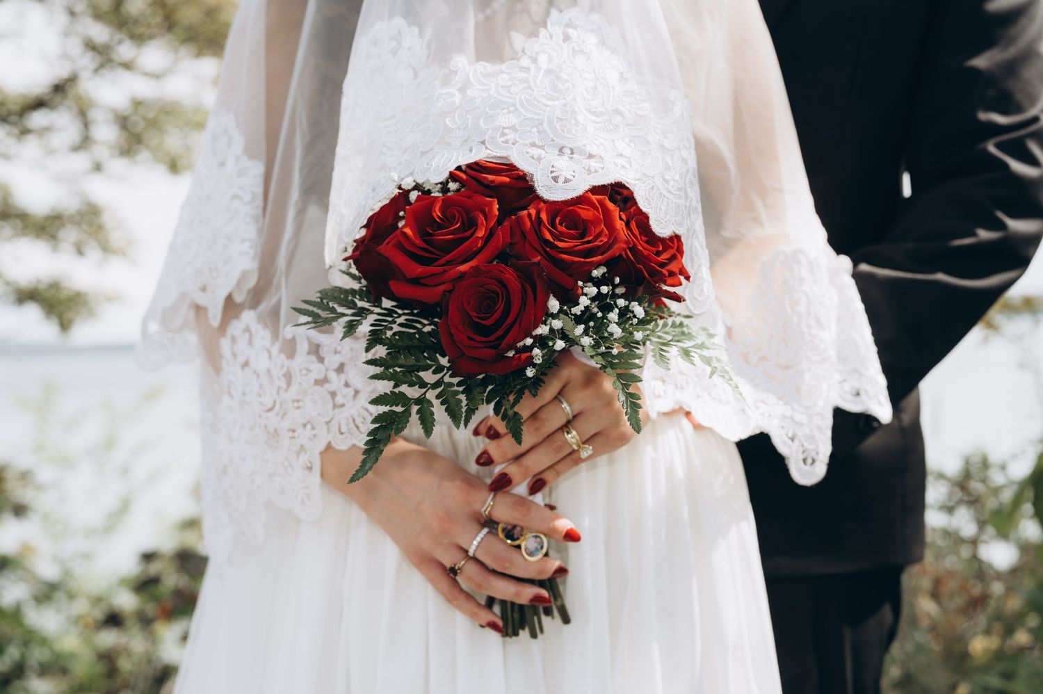A cropped wedding photo collage showing elegant white dress details and deep red rose bouquets.