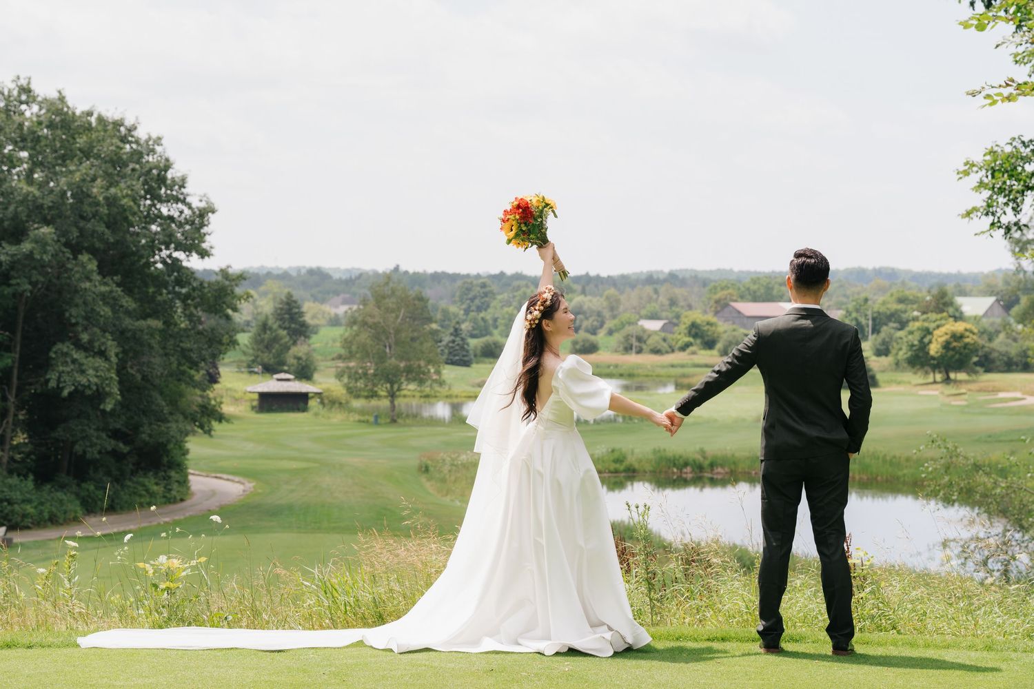 Bride and groom posing by the scenic pond at Pheasant Run Golf Club, professional photography by AZ Photo Studio.