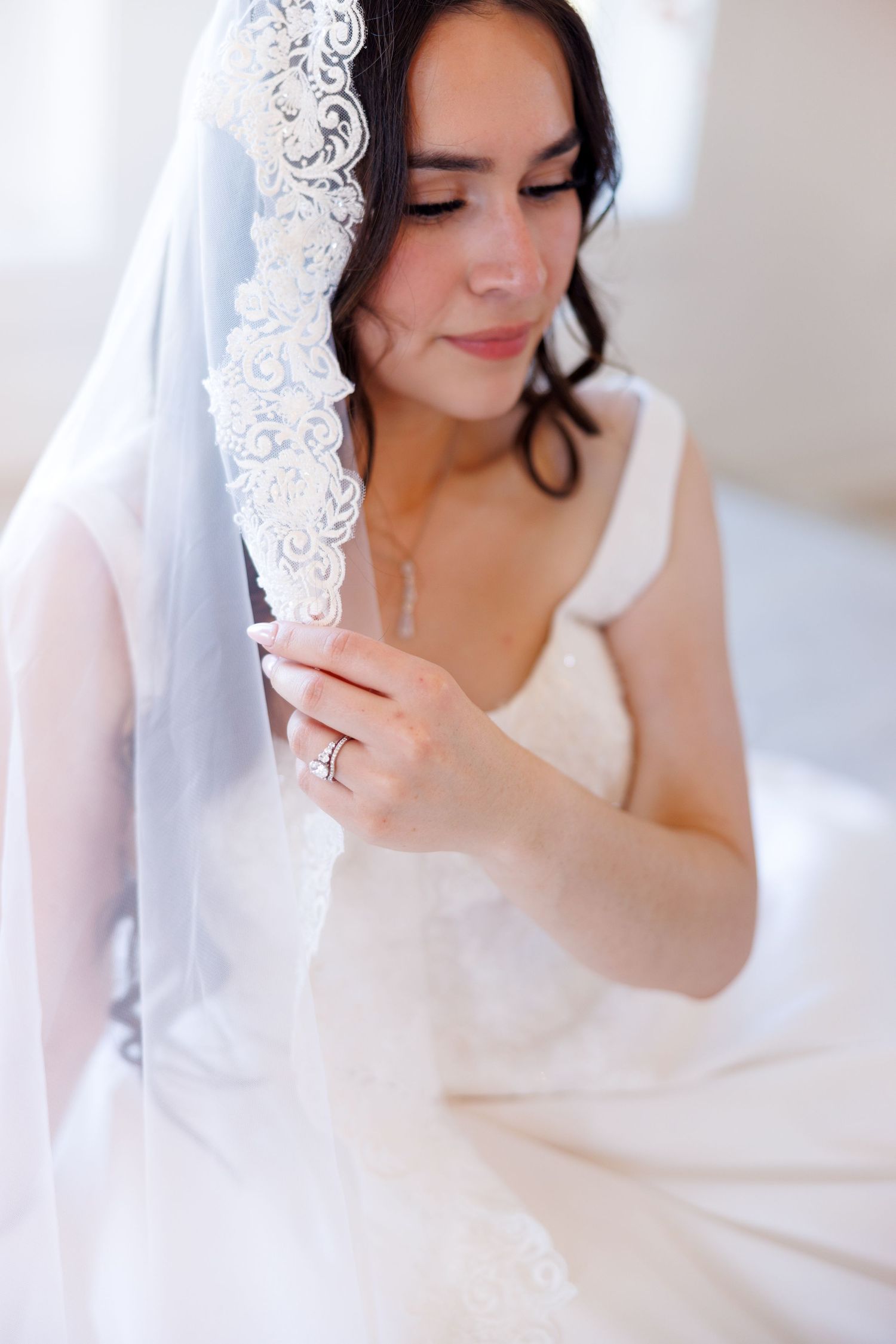 Close-up shots of bride with lace veil in soft natural lighting.