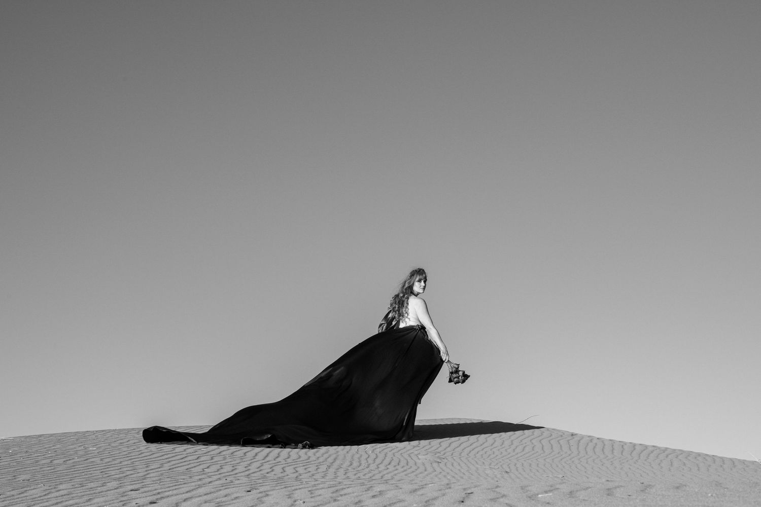 Women stands on the top of the sand hill in the Nevada desert.  Photo by Wornden Ly
