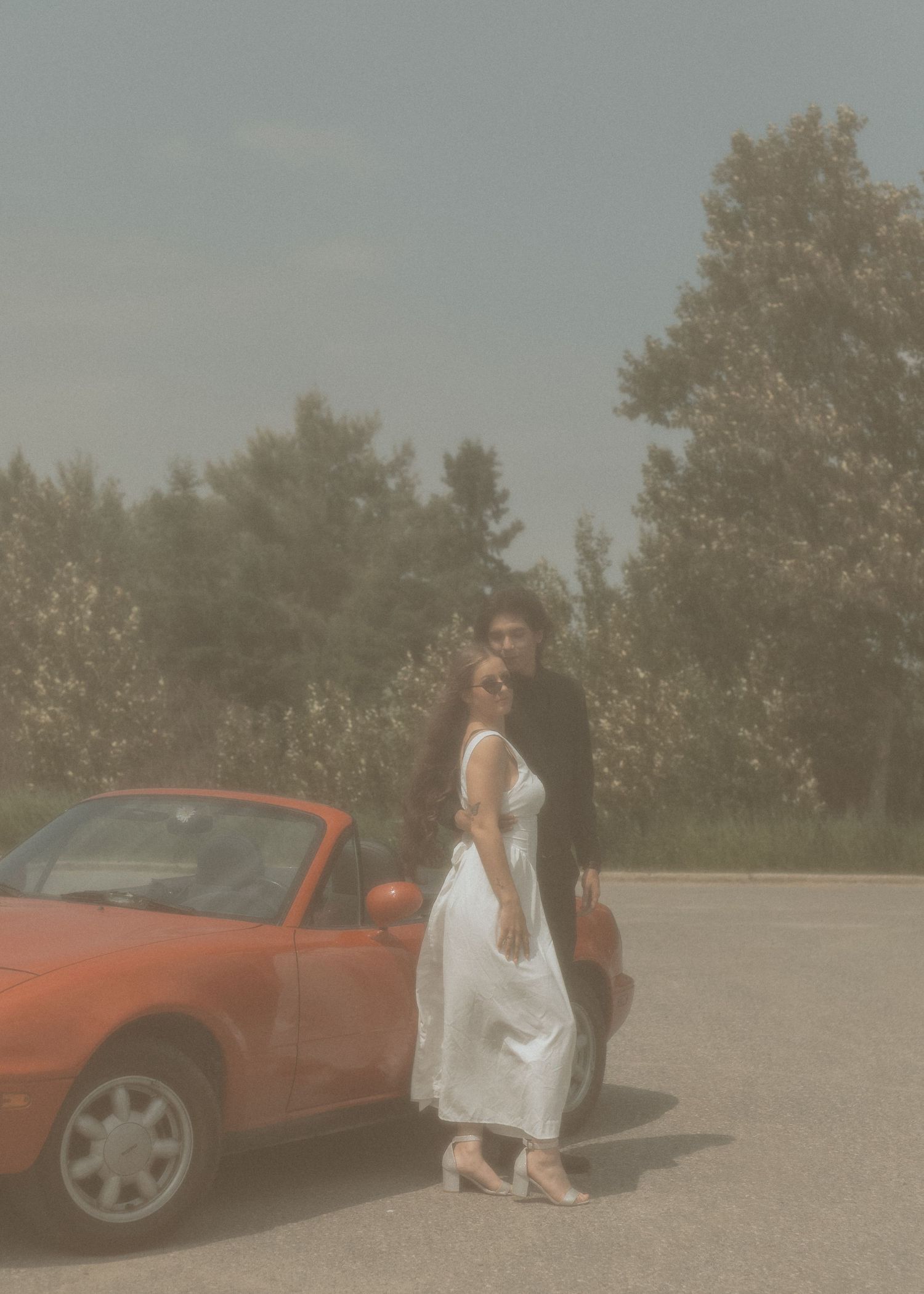 Wedding Photographer in Sudbury Ontario captures happy engagement photography with red car