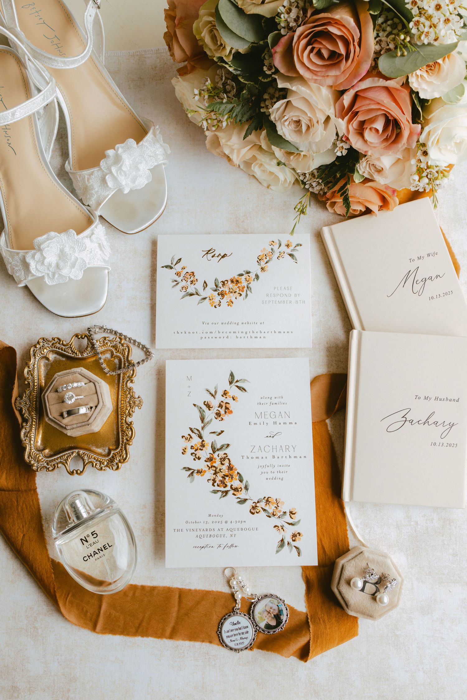 Wedding flat lay with floral invitations, bridal shoes, rings, bouquet, and Chanel perfume.
