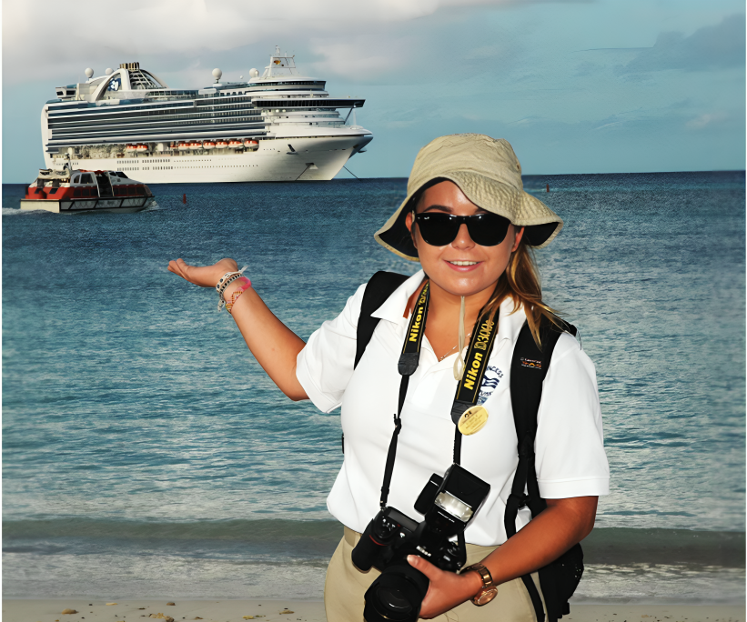 Female photographer with Nikon camera posing on tropical beach with cruise ship in background.