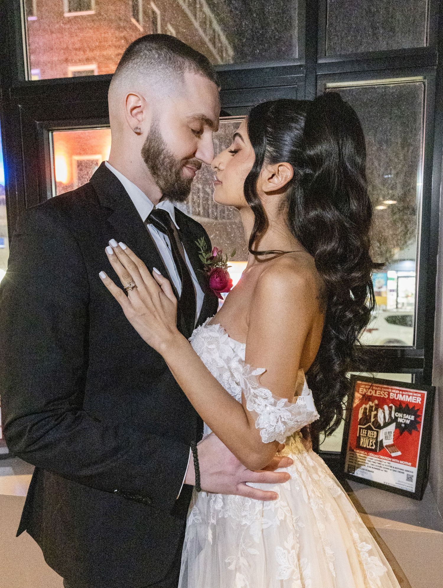 Bride and groom share a romantic moment in a softly lit wedding venue entrance.
