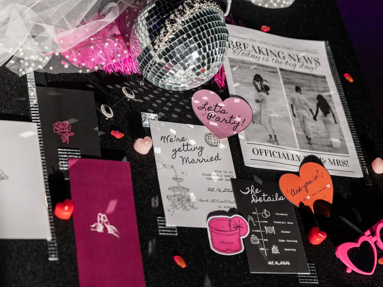 Bachelorette party table with disco ball, pink decorations, and breaking news wedding announcement.