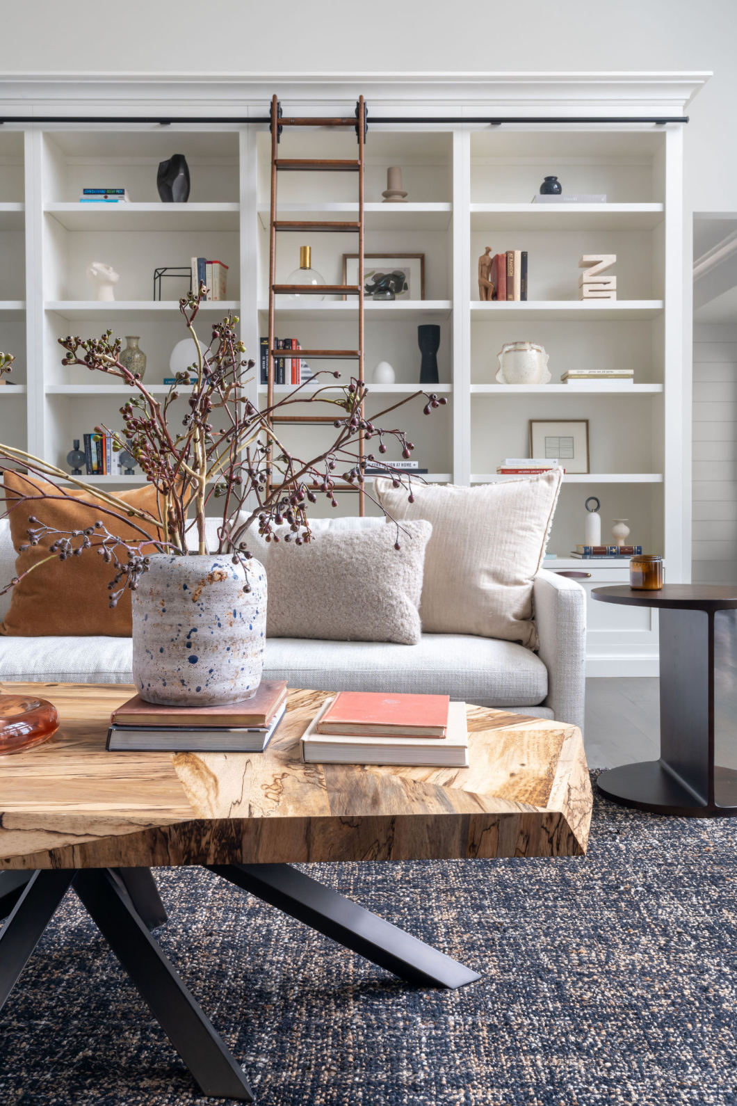 Bright living room with white built-in shelves, live-edge coffee table, and cozy sofa.