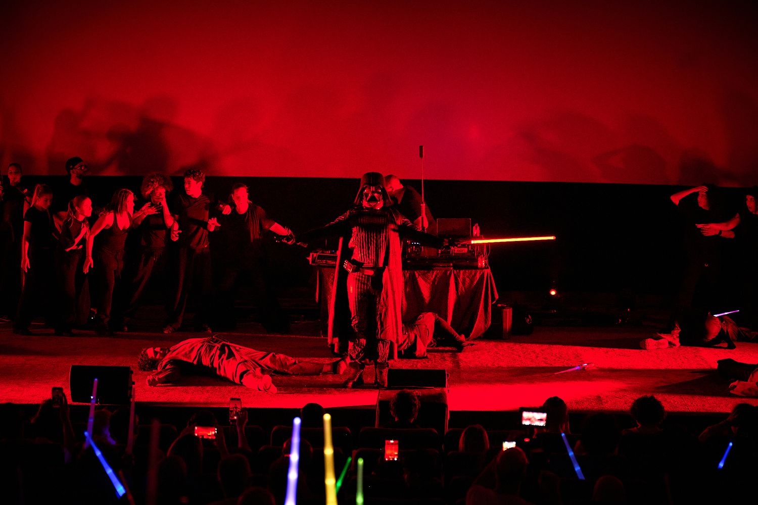 Star Wars Darth Vader stage performance under dramatic red lighting with lightsabers and costumed performers.