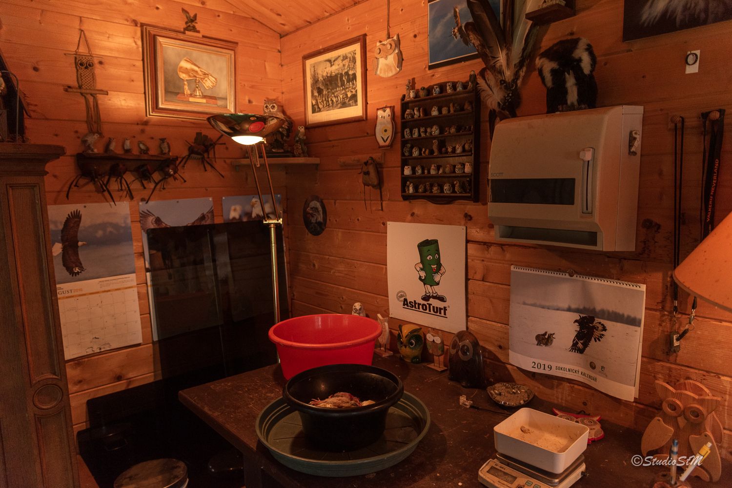 Rustic wooden cabin interior with red basin, heater, vintage decor, and warm ambient lighting.