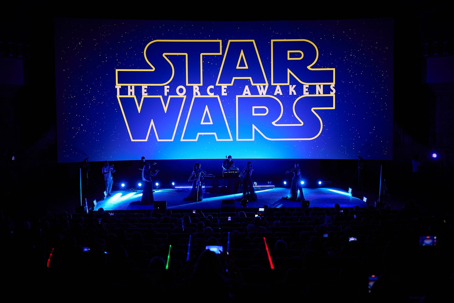 Star Wars: The Force Awakens logo displayed on a large cinema screen with blue stage lighting.