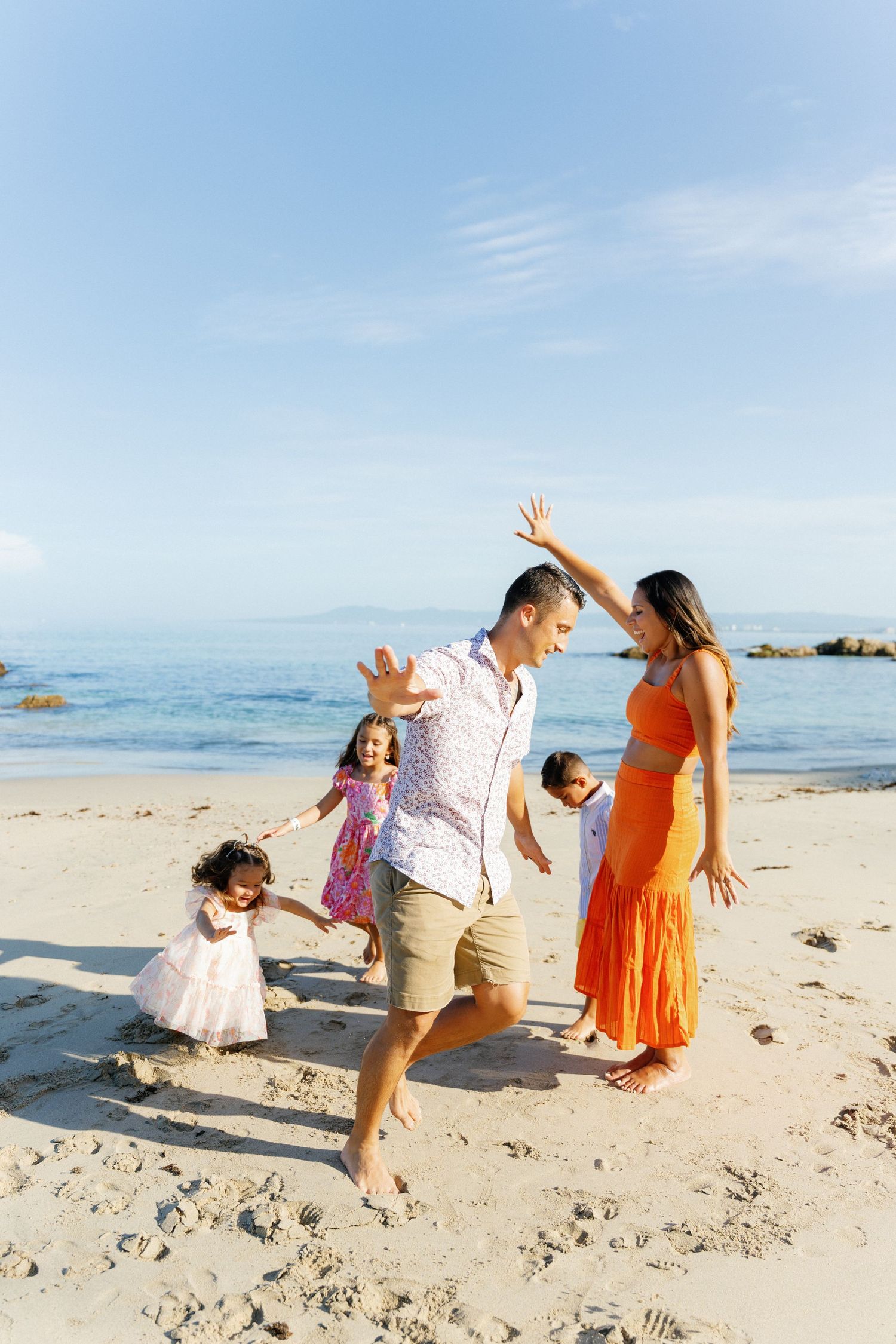Mom and dad playing airplane with three kids on the beach in Puerto Vallarta Mexico — Marina Pochepkina Photography