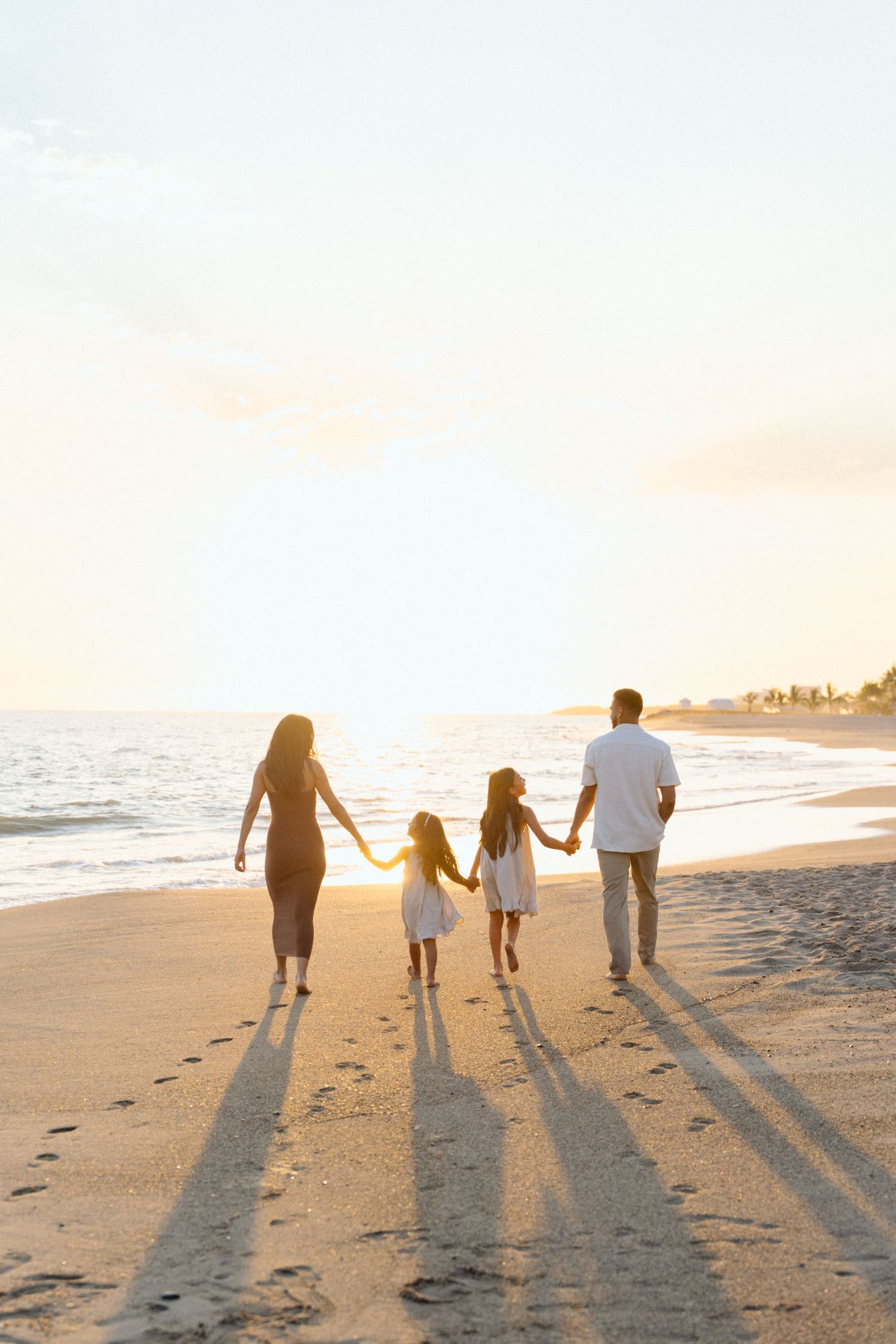 Family of four walking along the beach at golden hour in Puerto Vallarta Mexico — Marina Pochepkina Photography