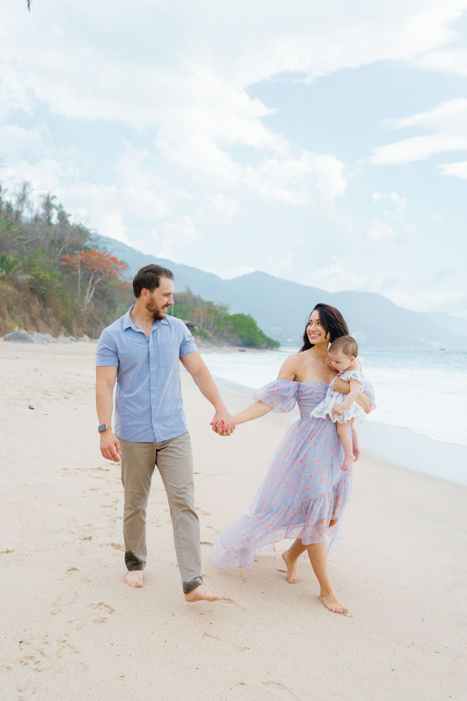 Mom holding baby while walking hand in hand with husband on the beach in Puerto Vallarta Mexico — Marina Pochepkina Photography