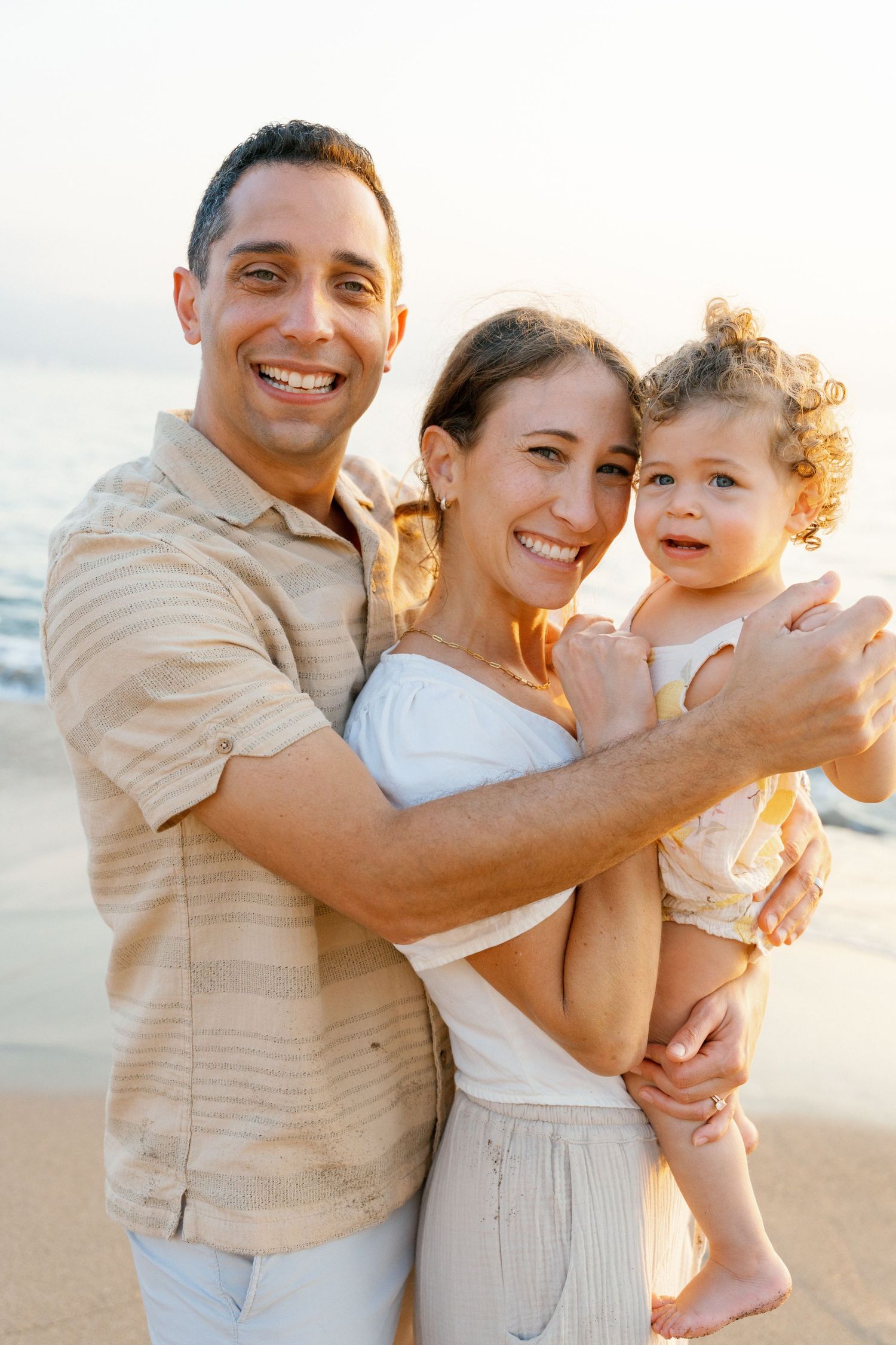 Parents holds baby and smile to camera in Puerto vallarta - Marina Pochepkina photograpy