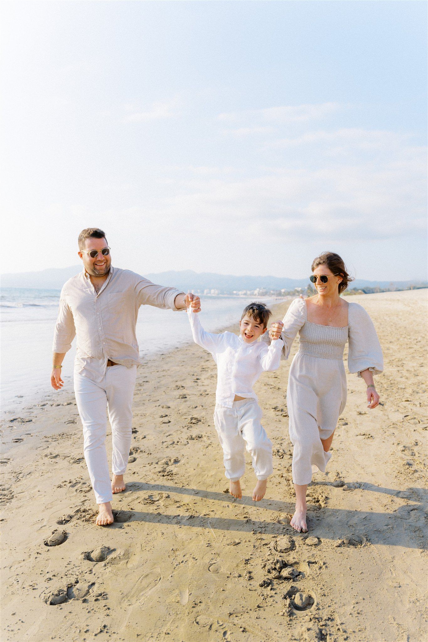 Family walking toward the camera with little boy jumping on the beach in Nuevo Vallarta Mexico — Marina Pochepkina Photography