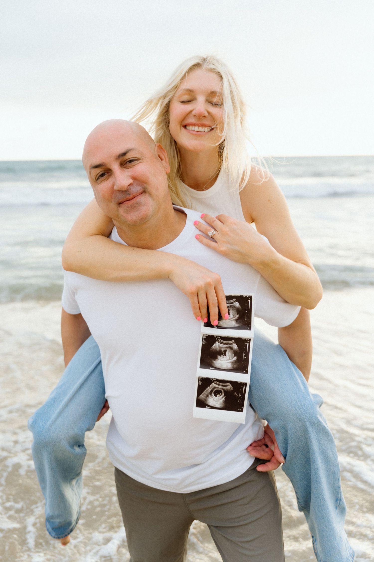 Happy couple on beach sharing pregnancy ultrasound photos in Puerto Vallarta — Marina Pochepkina photography