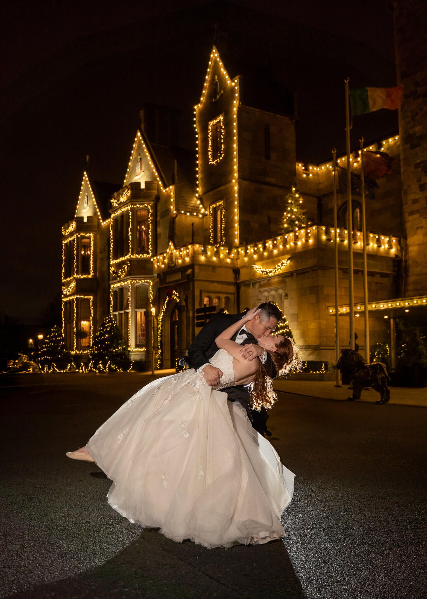 A groom dips his bride in a white gown for a romantic kiss at Clontarf Castle Dublin photo by AK wedding photography and videography.