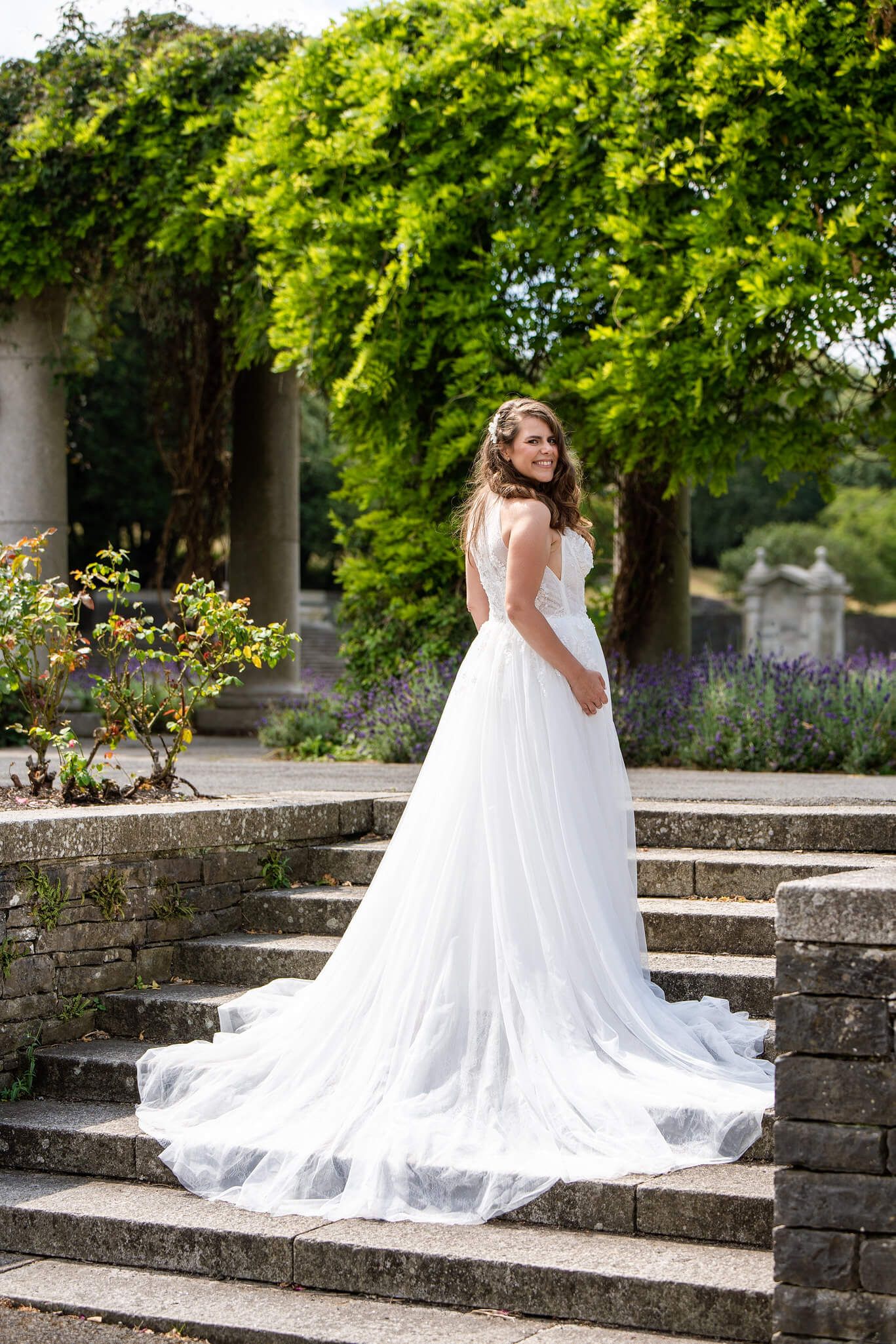 Bride in a white tulle wedding gown on steps at Irish memorial gardens Dublin photographed by AK Photography & Videography