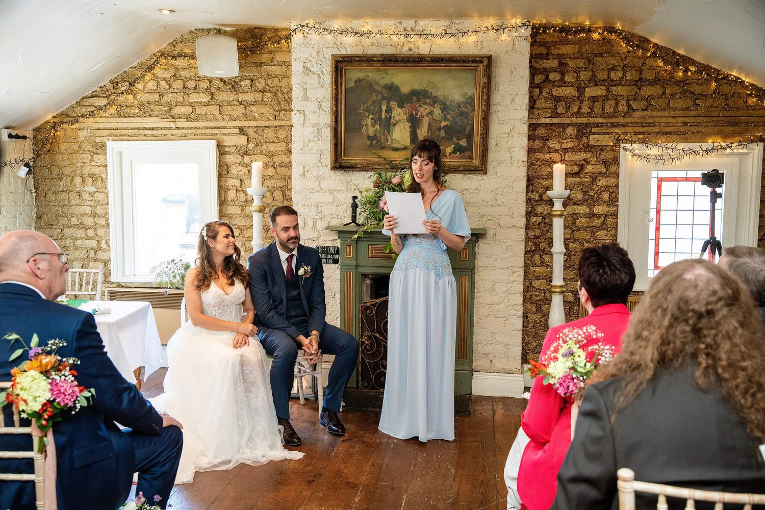 A bride and groom sit before a celebrant reading a script during an intimate wedding at The Anglers Rest photo by AK wedding photography.