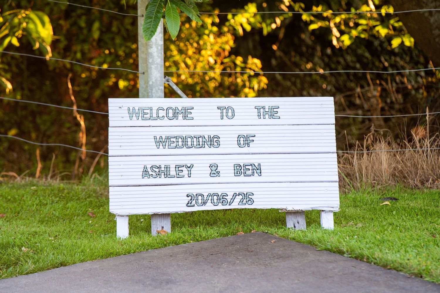 Welcome sign for the wedding of Ashley and Ben on 20/06/26 displayed on a white letterboard outdoors.