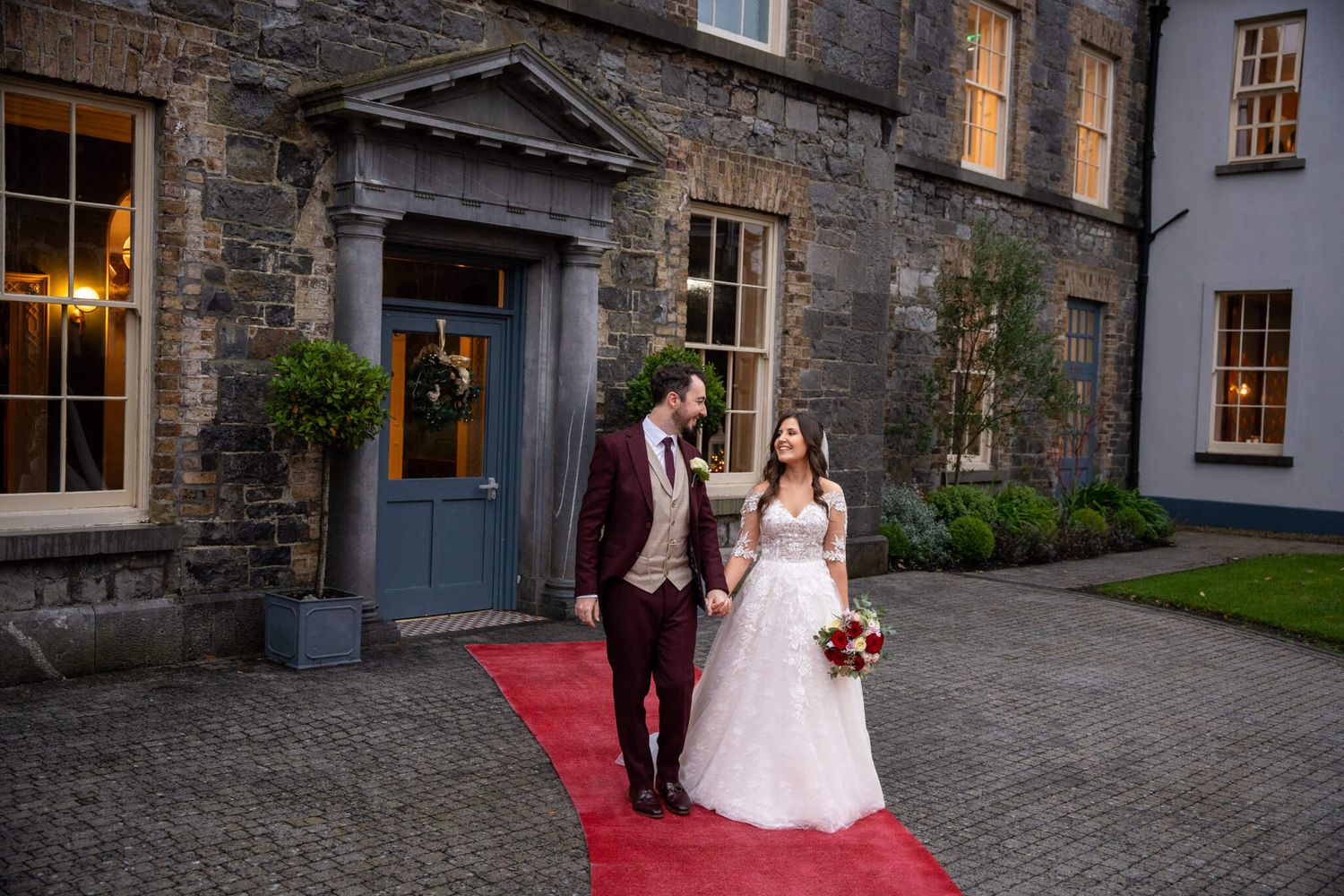 Bride and groom hold hands in front of the Abbey, Athy, photo by AK wedding photography and videography.
