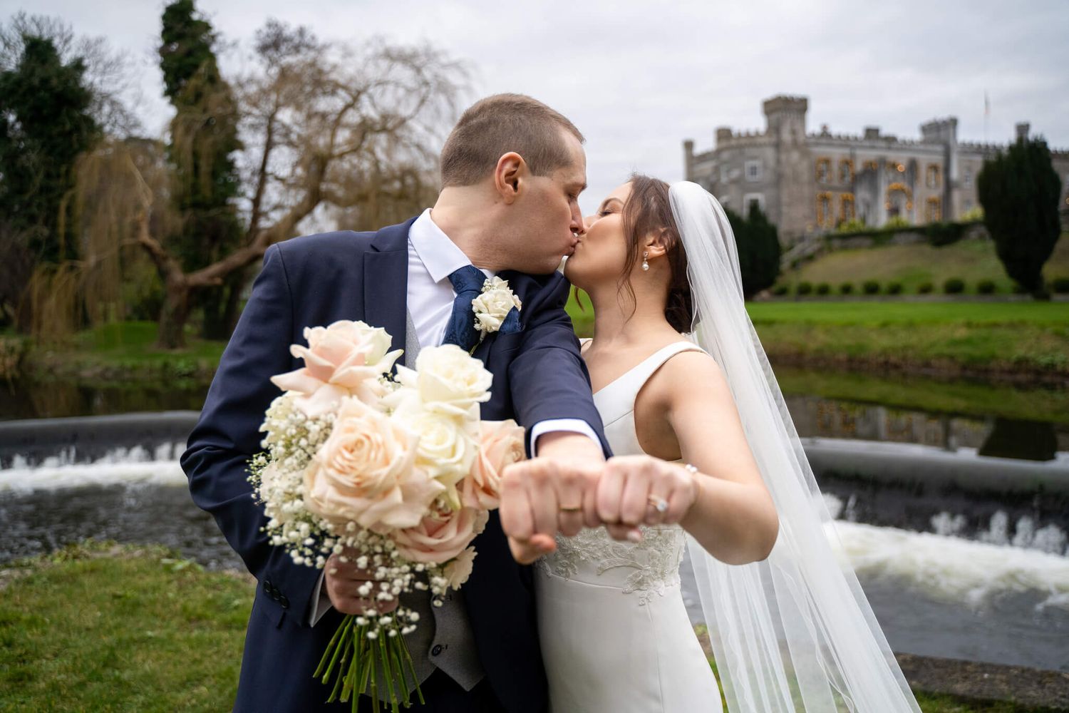 Bride and groom kiss while at the weir at Castlebellingham photo by AK wedding photography and videography.
