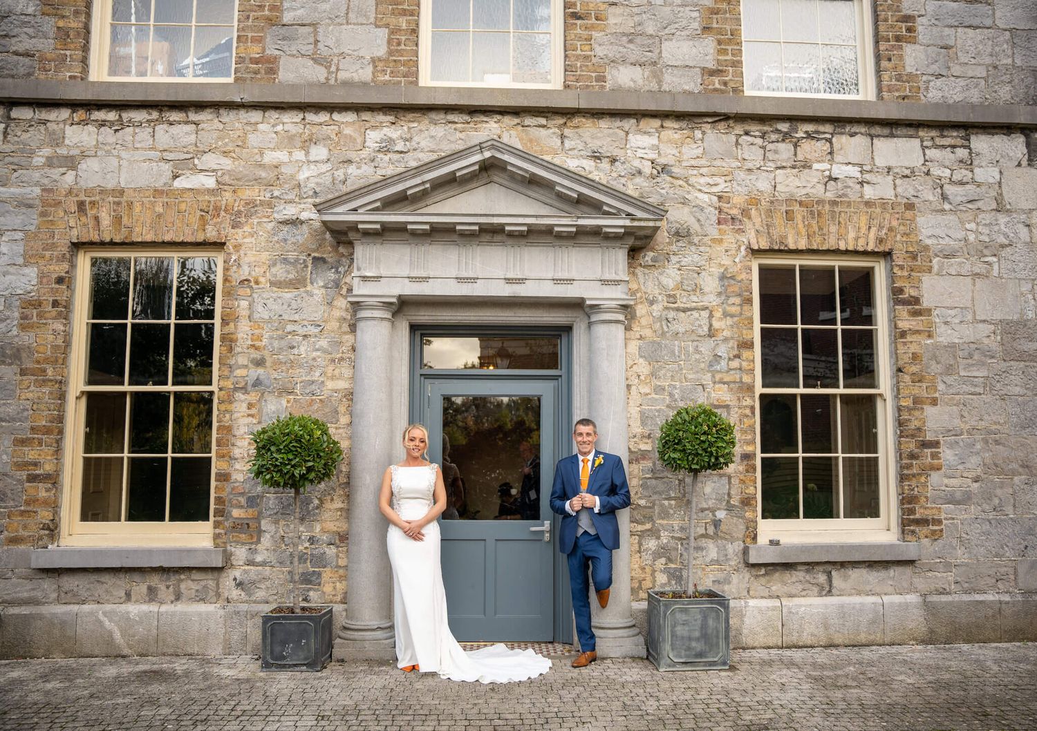 Bride and groom pose in front of a the Abbey Athy, County Kildare. Photo by AK wedding photography and videography.
