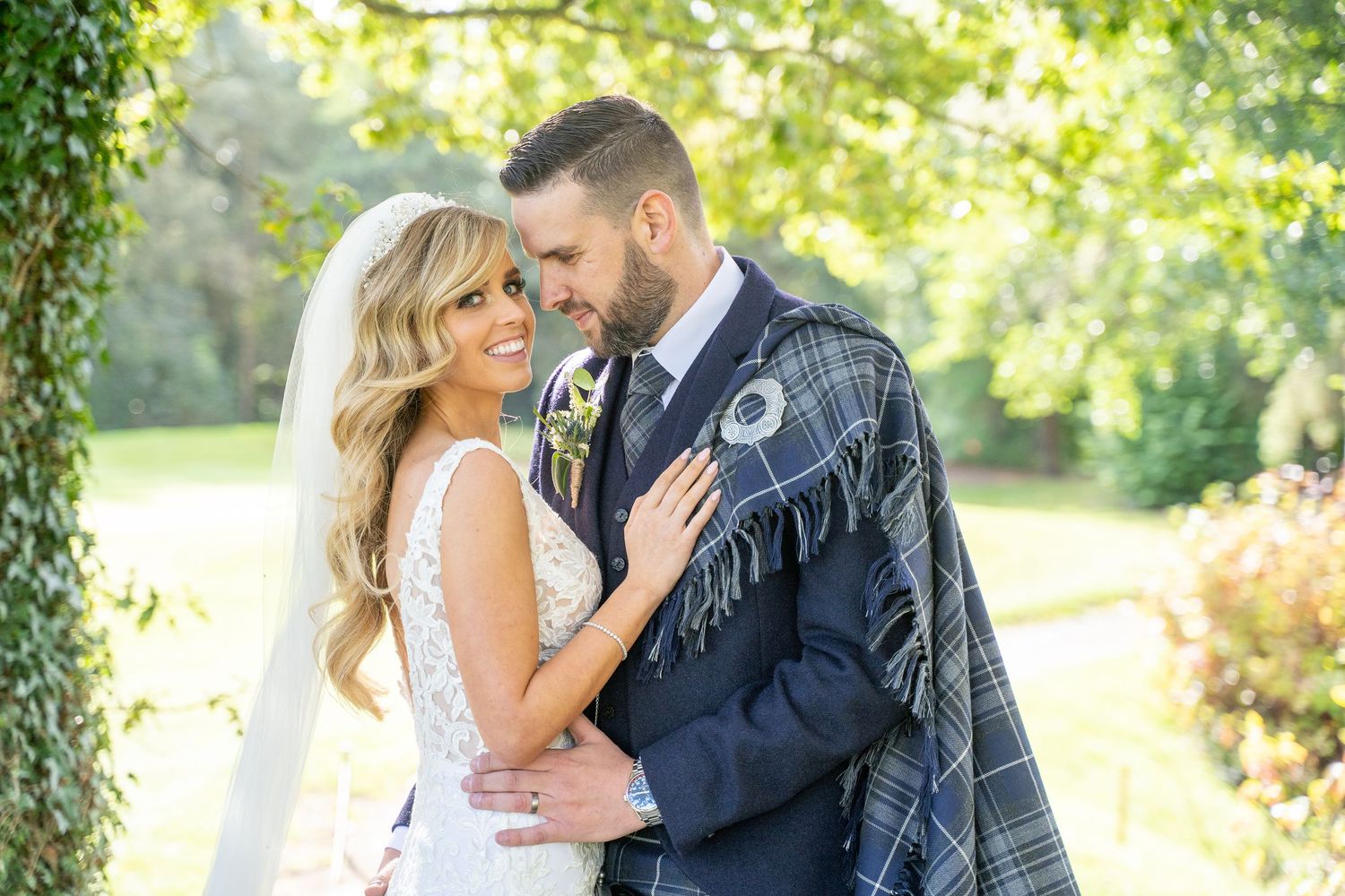 A romantic couple shares tender moments in a lush garden setting during their wedding photoshoot in Mount Wolseley Hotel