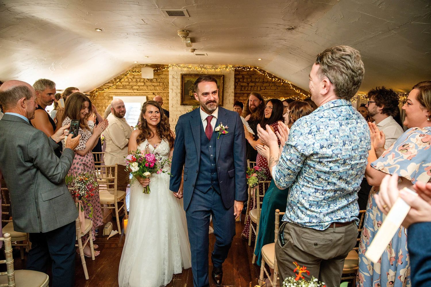 Smiling bride and groom walk down the aisle in the historic Anglers rest Dublin photo by AK wedding photography.