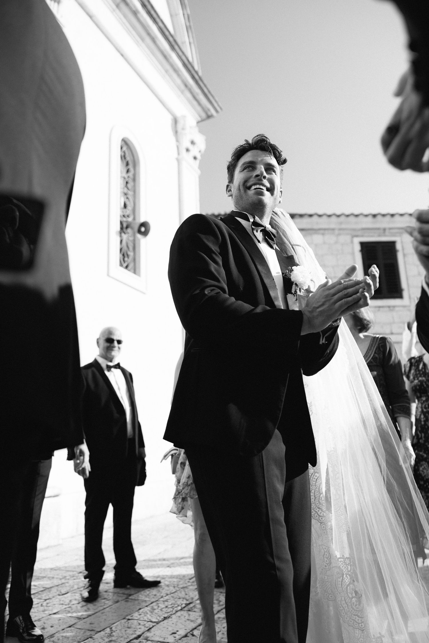Black and white photos showing celebratory moments at an indoor wedding venue.