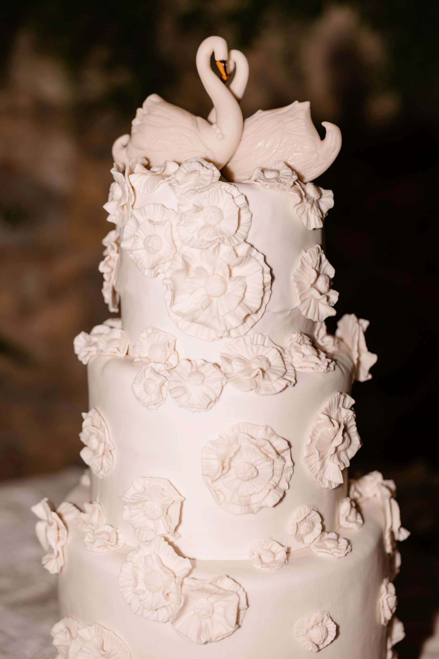 Elegant white wedding cake decorated with delicate sugar flowers and intricate details.