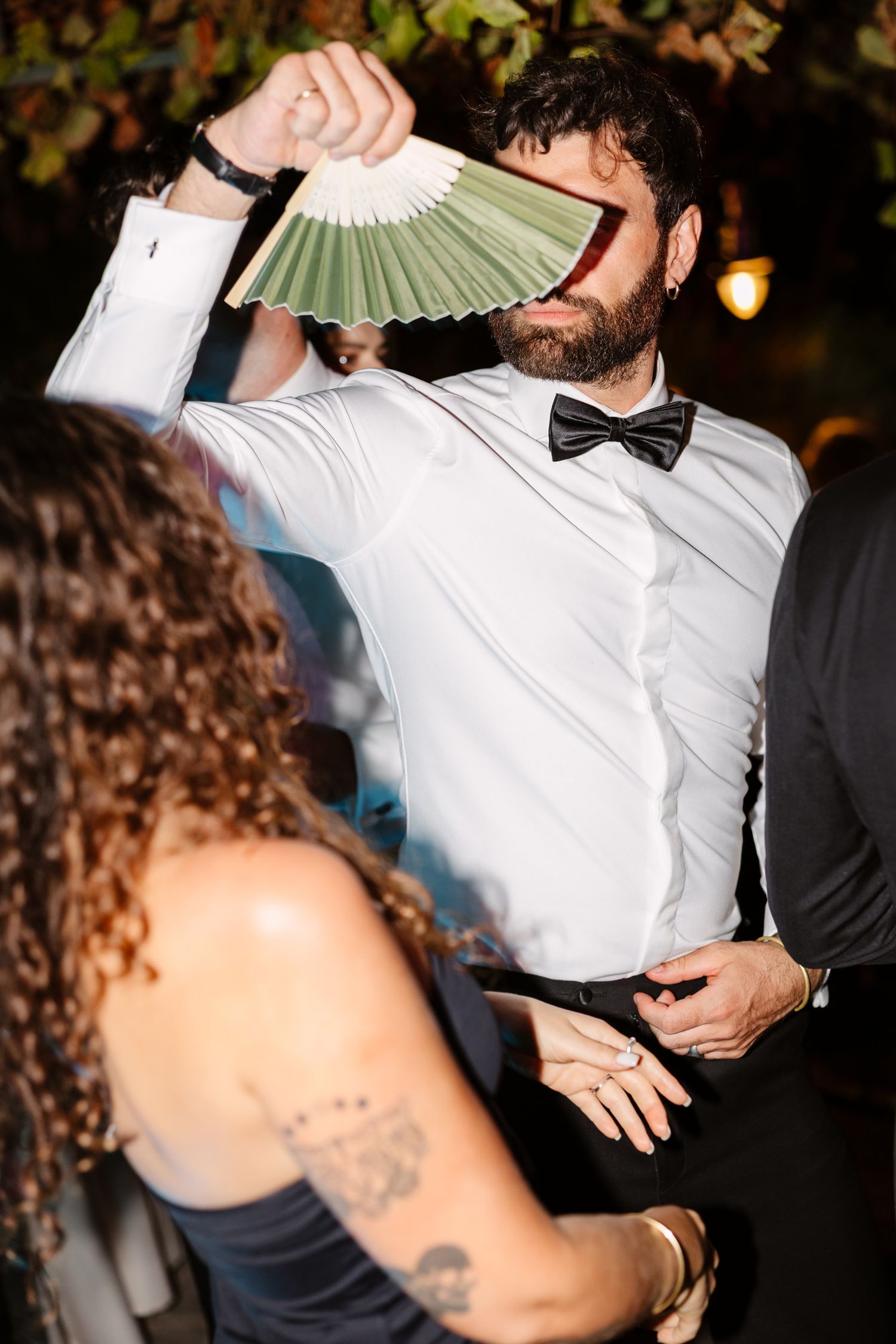 Wedding guest with a decorative fan dancing at an evening celebration. Hvar, Croatia