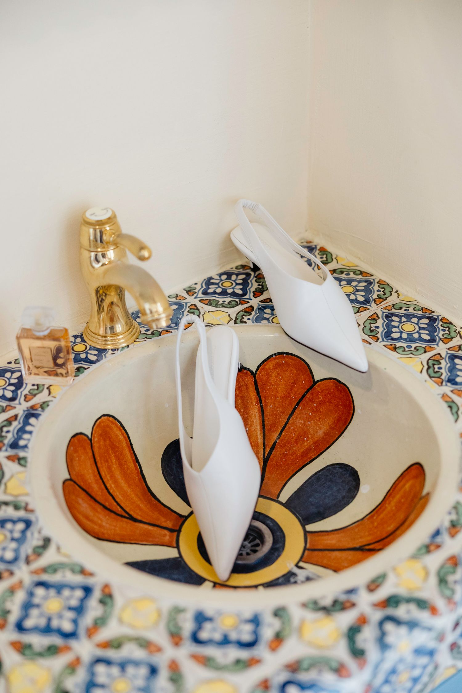 Decorative orange and blue ceramic butterfly ornament displayed on patterned tile background.