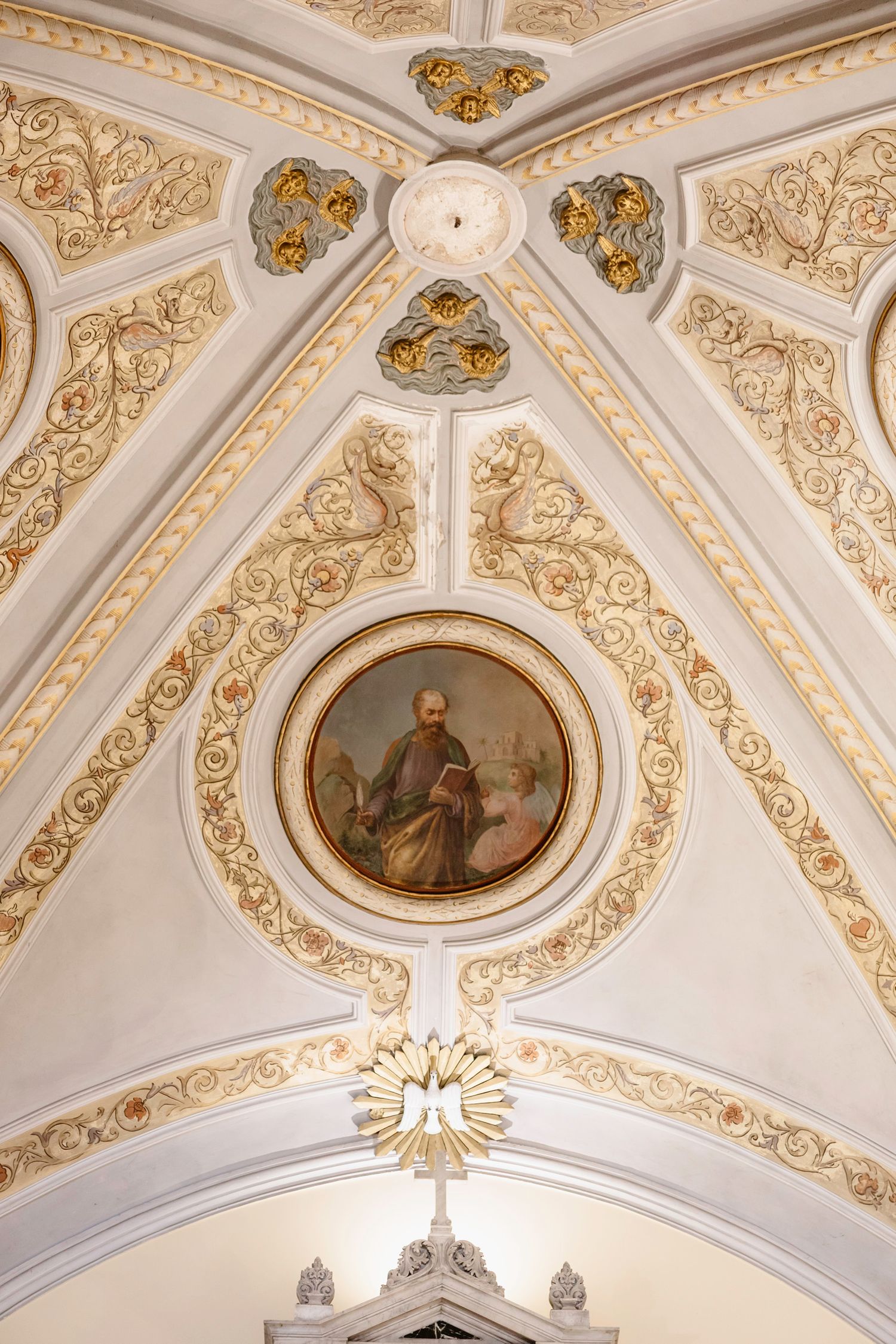 Detailed ceiling fresco in church with ornate gold baroque decorations and religious artwork.